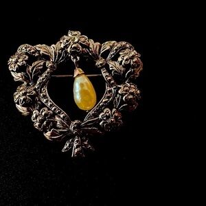 A beautiful vintage silver tone wreath brooch with a faux pearl
